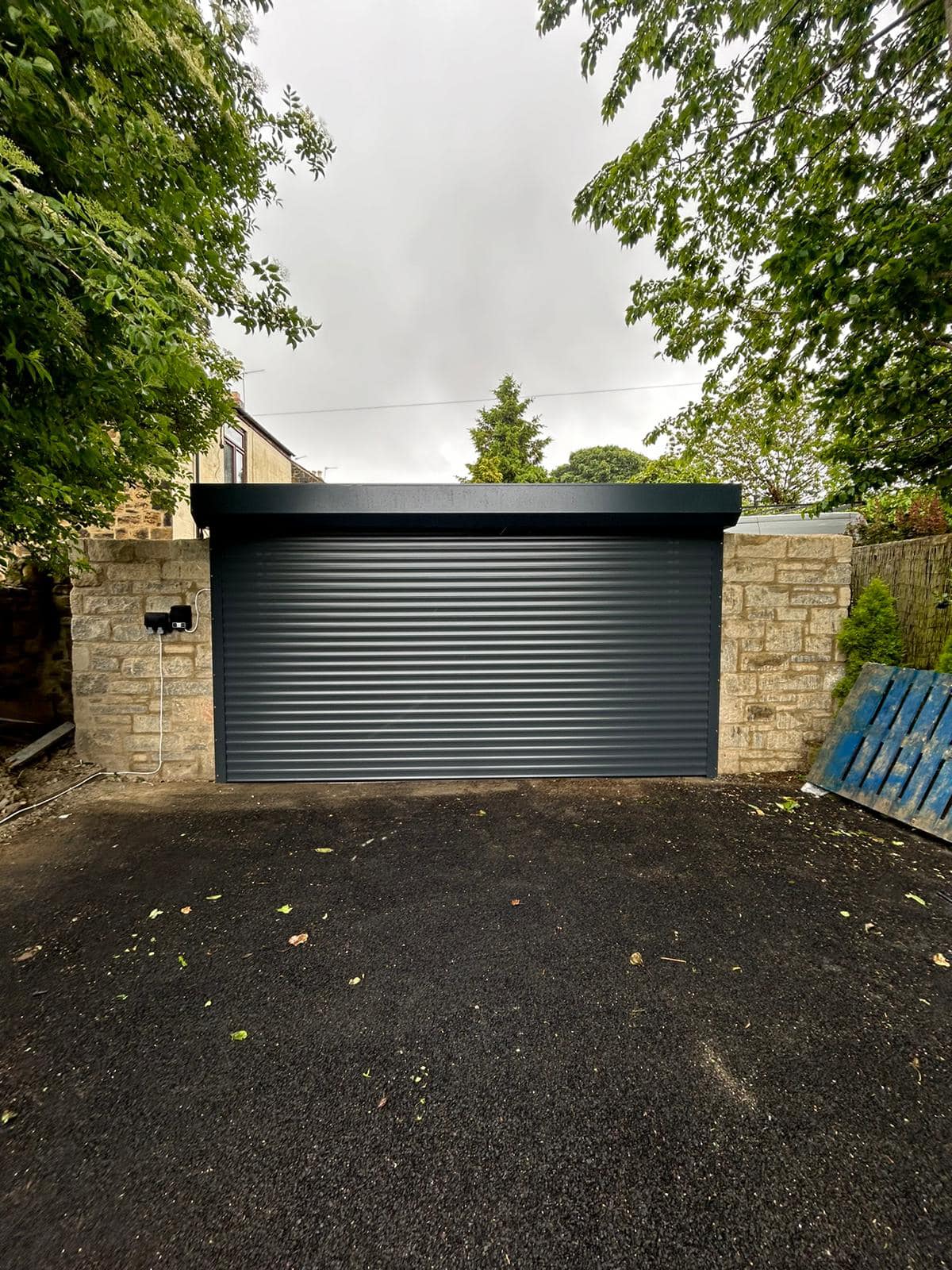 Black roller garage door on a brick built home